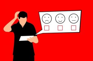 Illustration of a person holding a piece of paper and scratching their head. Above them is a speech bubble containing three faces—sad, happy, and neutral—each with an empty checkbox below. The background is red.