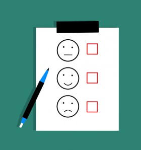 Feedback form with three faces representing neutral, happy, and sad emotions, each with a corresponding checkbox. A pen is placed beside the form.