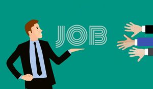 A person in a suit extends an arm toward the word "JOB" in stylized text. On the right side of the image, several hands are reaching toward the word, symbolizing competition or interest in employment opportunities.