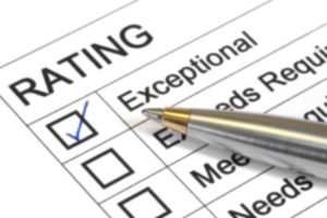 Rating form with four options: exceptional, exceeds requirements, meets requirements, and needs improvement. The exceptional option is marked with a blue checkmark. A pen is positioned near the checkboxes.