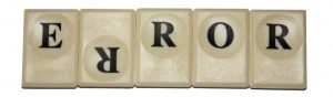 Five Scrabble tiles arranged to spell the word error, with the second tile showing an upside-down letter R.